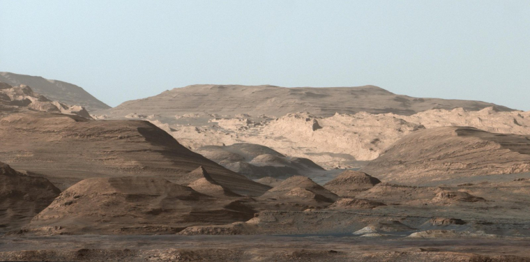 An image taken by the Curiosity Rover MastCam  instrument shows layered sedimentary rocks composing Mount Sharp. The rover has been driving from the floor of Gale crater up through the rocks within these hills in order to understand how the rocks change from lower in the section (older) to higher in the section (younger). The rover have traversed rocks over >400 meters of elevation from the beginning of the mission. (Image credit:  NASA's Mars Curiosity Rover)